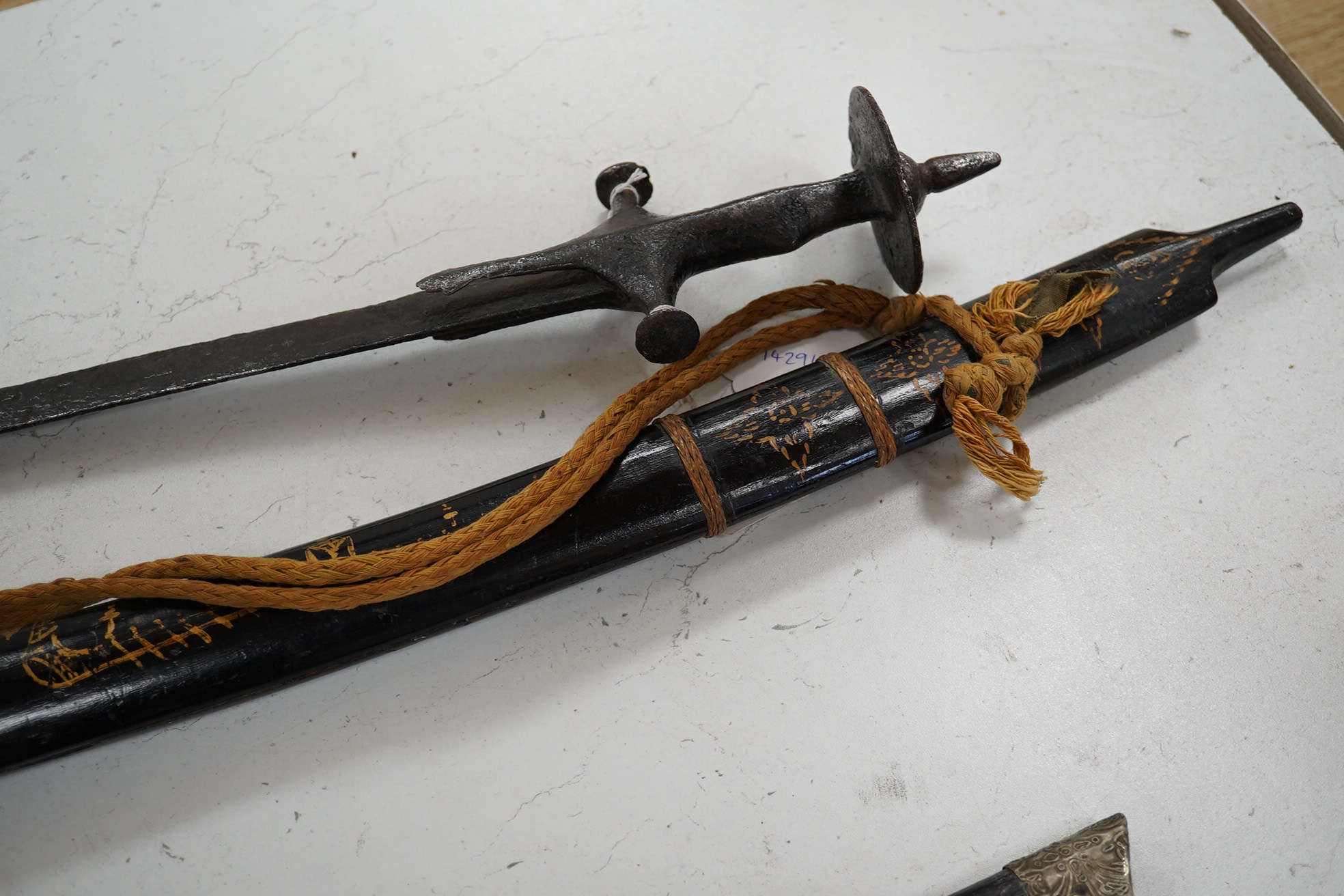 Four bladed weapons; an Indian sword Tulwar, blade 68.5cm. Condition - poor, heavily pitted., A Nepalese Kukri. Condition - fair., A Thai sword Dha, with a lacquered hilt and wooden scabbard, blade 56cm. Condition - fair